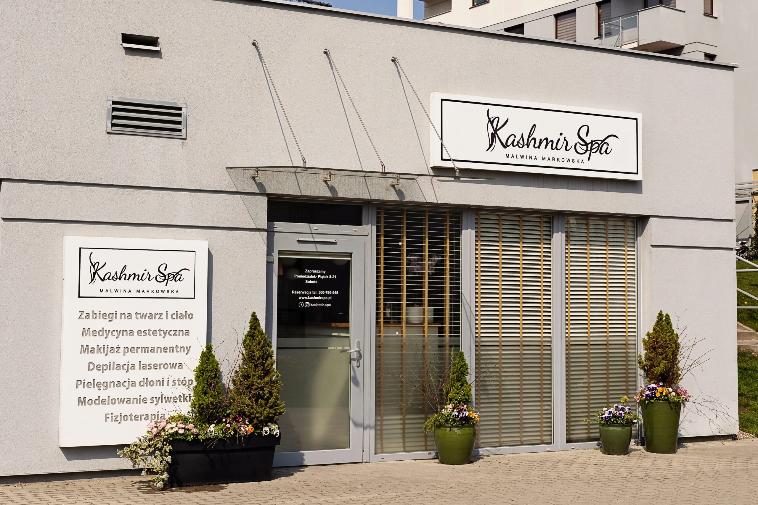Elegancki budynek Kashmir SPA Malwina Markowska, zewnętrzna fasada salonu kosmetycznego z wyeksponowanymi reklamami usług.