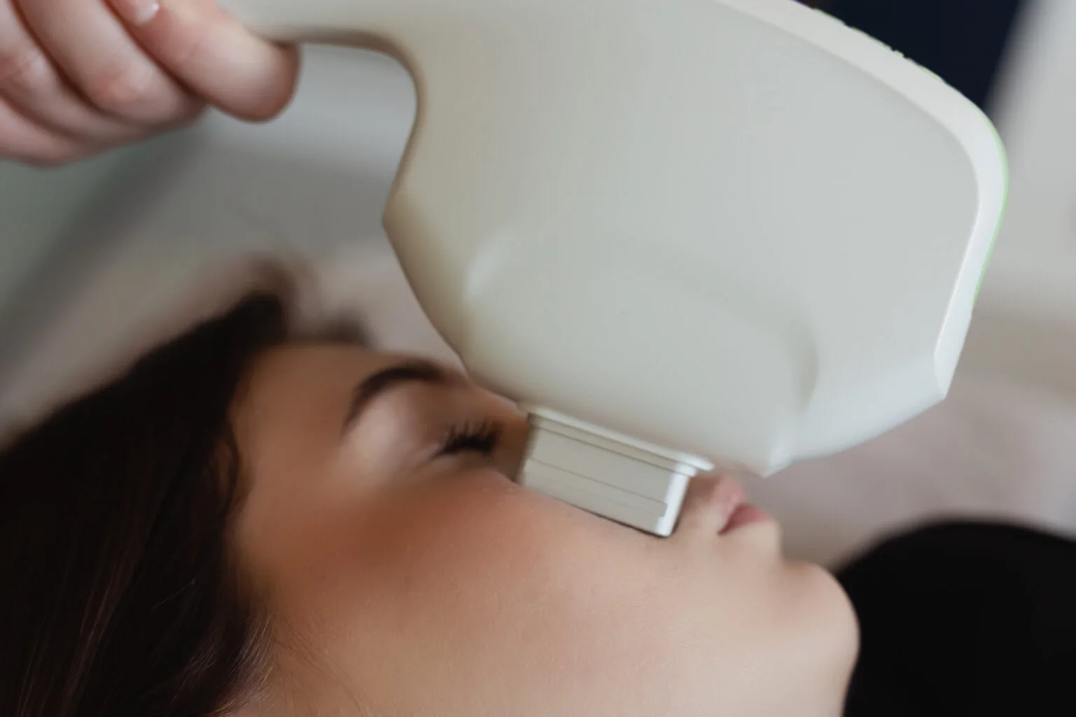 Kobieta poddaje się zabiegowi ZAFFIRO, korzystając z nowoczesnego urządzenia kosmetycznego, aby odmłodzić skórę twarzy.