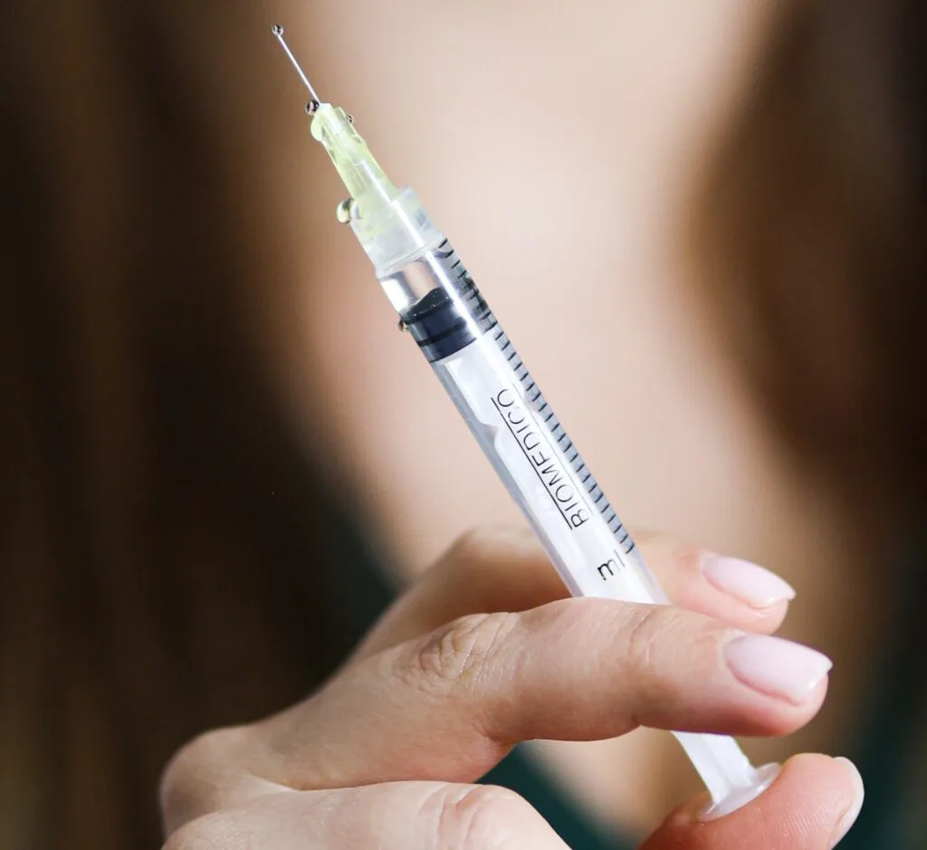 Strzykawka trzymana przez kosmetolog używana w zabiegu MEZOTERAPIA IGŁOWA