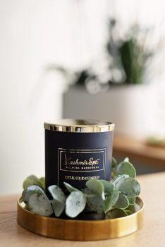 Galeria zdjęć przedstawiająca elegancką świecę zapachową od Kashmir SPA Malwina Markowska na złotej tacy.