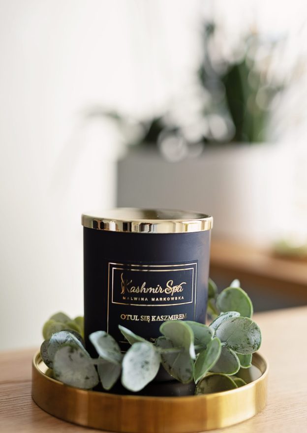 Galeria zdjęć przedstawiająca elegancką świecę zapachową od Kashmir SPA Malwina Markowska na złotej tacy.