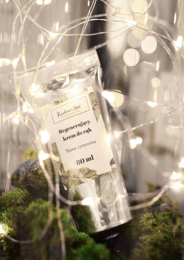 Opakowanie regenerującego kremu do rąk Kashmir SPA, otoczone dekoracyjnymi światłami i zielenią na 11 URODZINY Kashmir Spa.